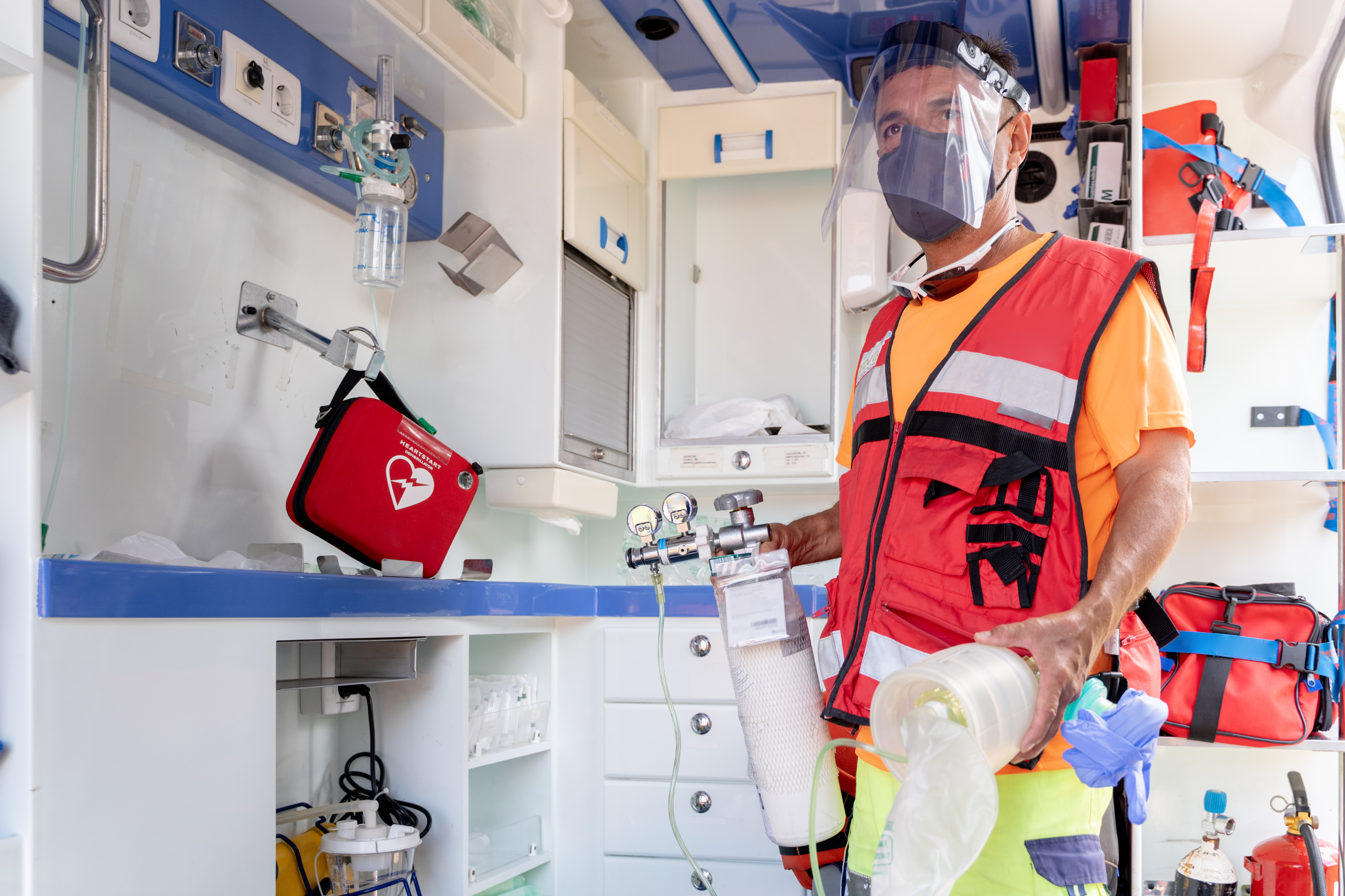 Lifeguard with facial mask working inside an ambulance